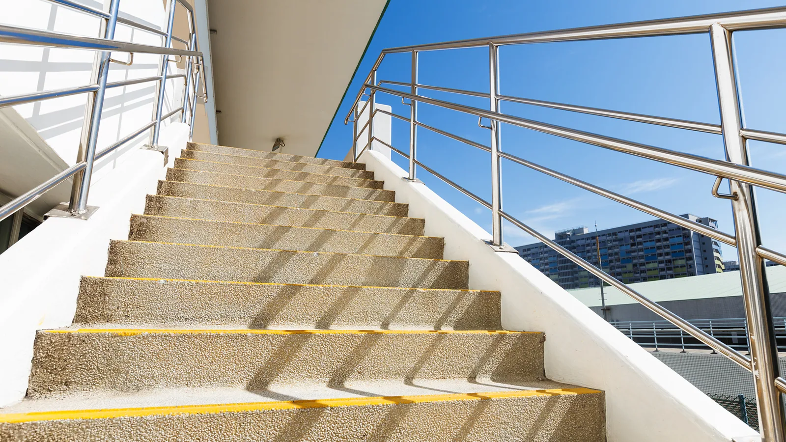Stainless steel handrails on a wide exterior flight of steps