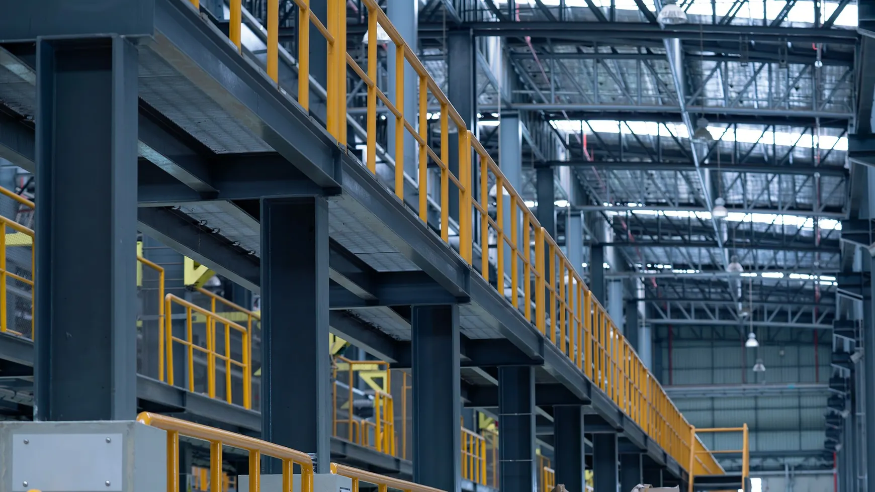 Steel platform with yellow guardrails inside an industrial factory
